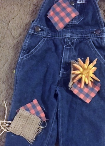 Easy DIY toddler scarecrow costume. Arrange the patches on the overalls to their desired position. 